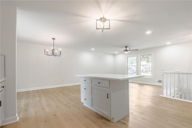 1101 SW Kingscross Rd, Blue Springs, MO 64014 - kitchen with light wood-type flooring, ceiling fan, a center island, a chandelier, and recessed lighting