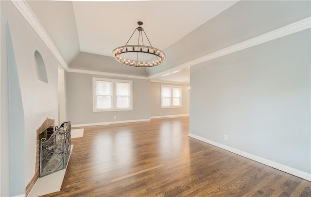 3624 Norledge Ave, Kansas City, MO 64123 - unfurnished living room featuring a chandelier, wood finished floors, a fireplace, lofted ceiling, and crown molding
