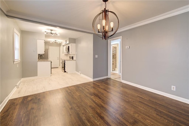 3624 Norledge Ave, Kansas City, MO 64123 - unfurnished living room with a chandelier, crown molding, and light wood-type flooring