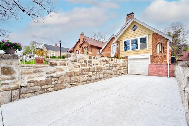 3624 Norledge Ave, Kansas City, MO 64123 - view of patio / terrace with concrete driveway and a garage