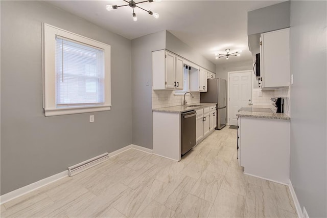 3624 Norledge Ave, Kansas City, MO 64123 - kitchen with stainless steel appliances, a chandelier, tasteful backsplash, and white cabinetry