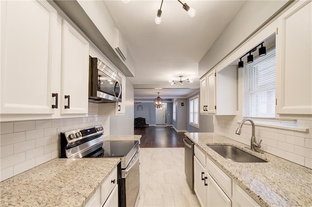 3624 Norledge Ave, Kansas City, MO 64123 - kitchen featuring stainless steel appliances, decorative backsplash, and white cabinets