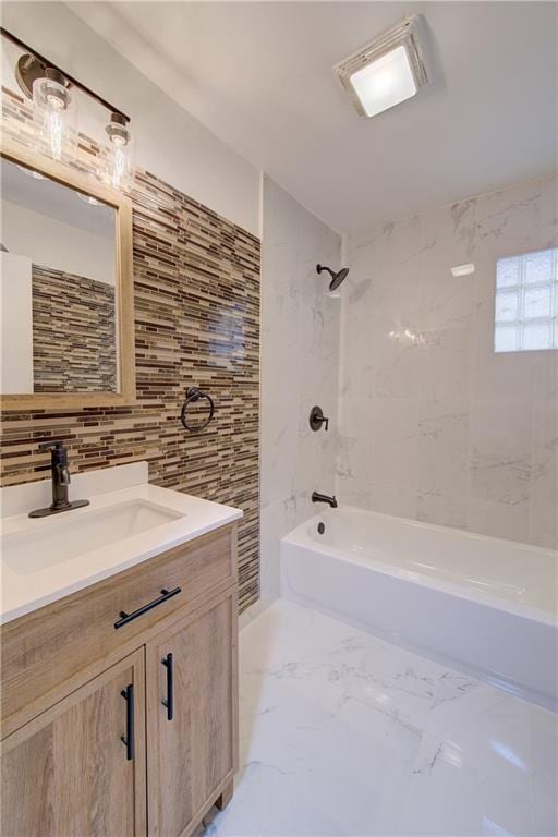 3624 Norledge Ave, Kansas City, MO 64123 - bathroom with vanity, washtub / shower combination, tile walls, decorative backsplash, and marble finish floors
