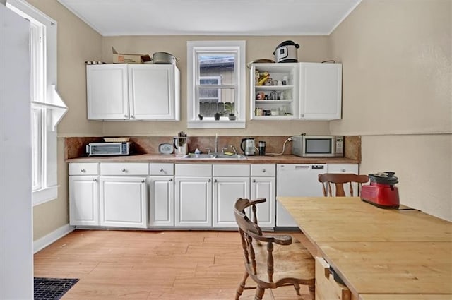 319 Market St, Leavenworth, KS 66048 - kitchen with stainless steel microwave, white dishwasher, white cabinets, light wood-style floors, and crown molding