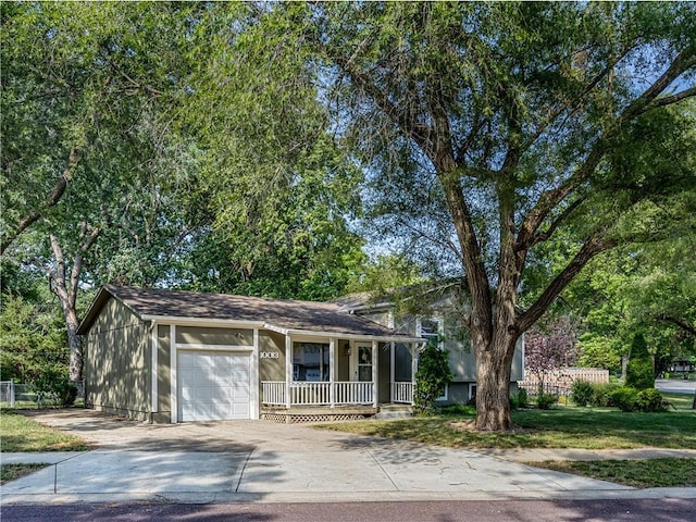 10013 Benson St, Overland Park, KS 66212 - tri-level home with covered porch, an attached garage, and concrete driveway