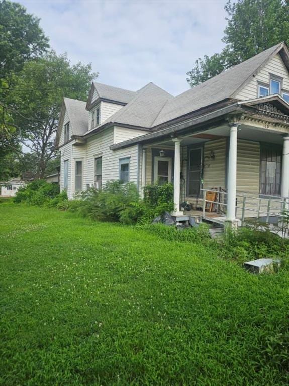 415 S Cherokee St, Girard, KS 66743 - back of house with covered porch, a yard, and roof with shingles
