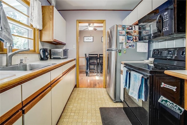 3021 Appleton Ave, Independence, MO 64052 - kitchen with black appliances, light flooring, light countertops, white cabinetry, and ceiling fan
