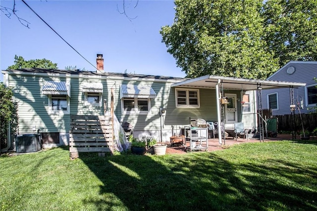 3021 Appleton Ave, Independence, MO 64052 - rear view of house with a lawn, a chimney, and a patio