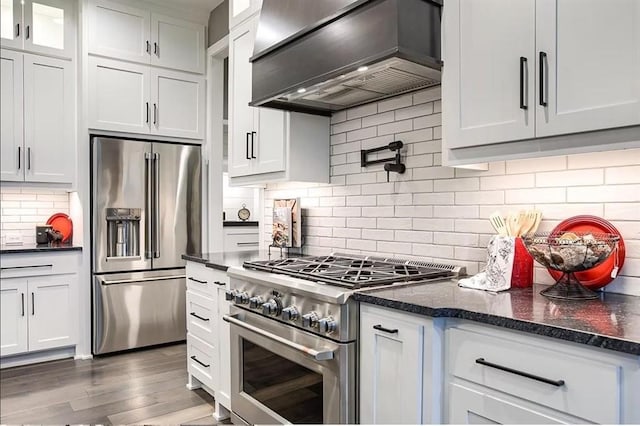 3409 W 187th St, Overland Park, KS 66085 - kitchen with high quality appliances, premium range hood, decorative backsplash, wood finished floors, and white cabinets