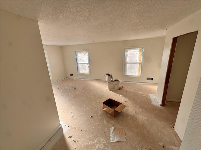 3649 S Park Ave, Independence, MO 64052 - spare room featuring a textured ceiling and baseboards