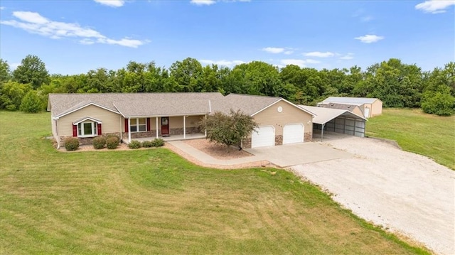 295 E 2300th Rd, Edgerton, KS 66021 - single story home with gravel driveway, covered porch, a front lawn, and an attached garage