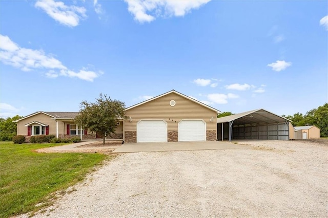 295 E 2300th Rd, Edgerton, KS 66021 - view of front of home featuring gravel driveway, a carport, a front lawn, stone siding, and an attached garage