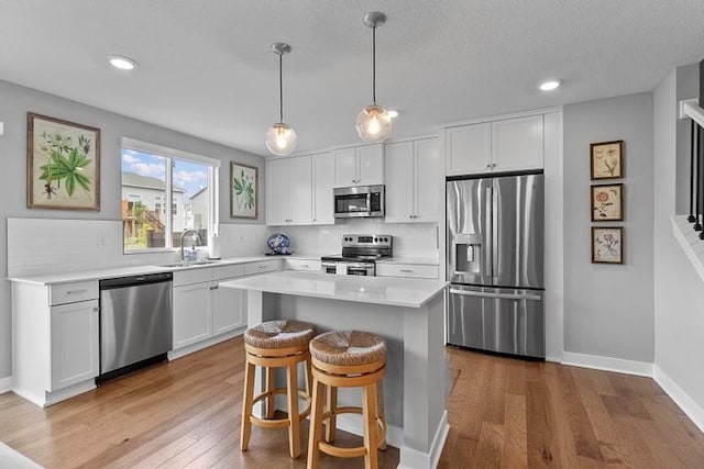 3726 SW Walsh Dr, Lees Summit, MO 64082 - kitchen featuring stainless steel appliances, backsplash, wood finished floors, light countertops, and recessed lighting