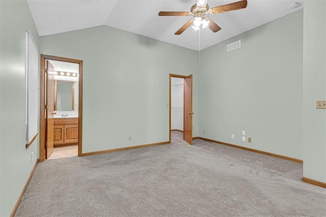 21213 W 51st Ter, Shawnee, KS 66218 - unfurnished bedroom featuring light carpet, vaulted ceiling, a walk in closet, a ceiling fan, and ensuite bath