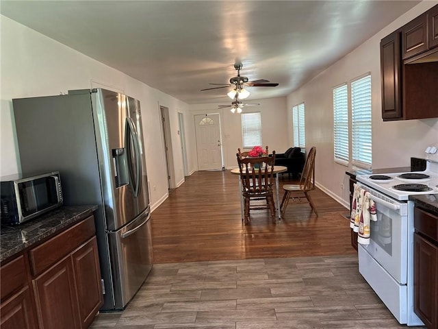 3009 N 33rd St, Kansas City, KS 66104 - kitchen with stainless steel appliances, ceiling fan, dark wood finished floors, dark brown cabinetry, and dark stone counters