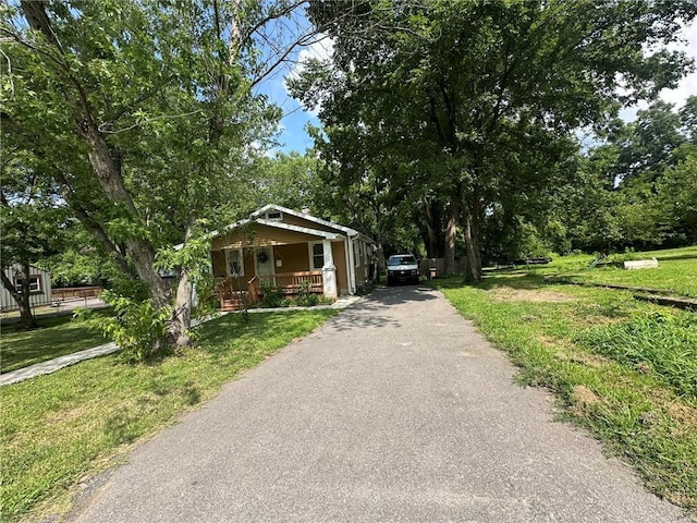 3009 N 33rd St, Kansas City, KS 66104 - bungalow with a porch, driveway, and a front yard