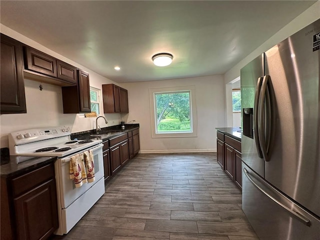 3009 N 33rd St, Kansas City, KS 66104 - kitchen with stainless steel fridge, electric stove, dark countertops, dark brown cabinetry, and dark wood finished floors