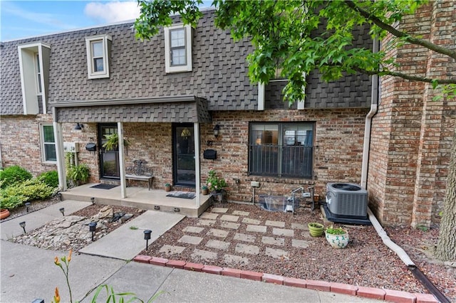 27 W Bannister Rd, Kansas City, MO 64114 - rear view of property featuring mansard roof, roof with shingles, and brick siding
