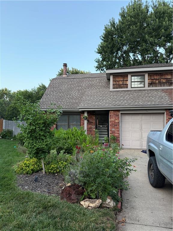 1616 E Elm Ter, Olathe, KS 66062 - view of front of home with roof with shingles, driveway, brick siding, and a garage