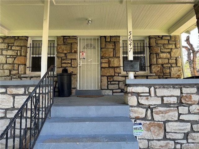 5647 Wayne Ave, Kansas City, MO 64110 - entrance to property with a porch and stone siding