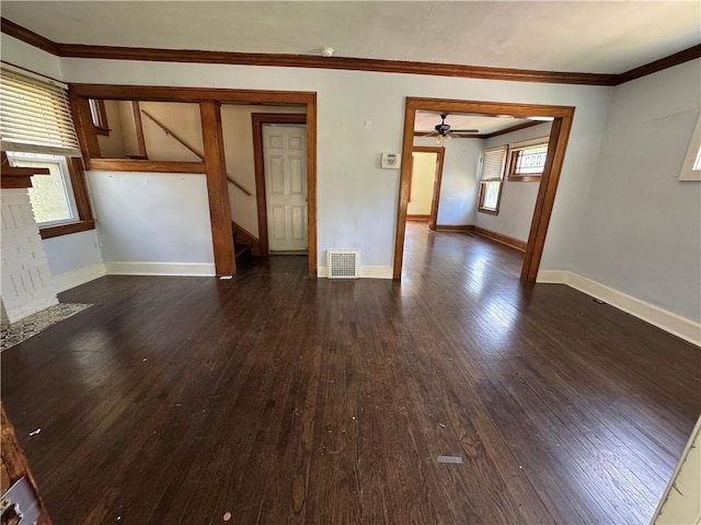 5647 Wayne Ave, Kansas City, MO 64110 - unfurnished living room featuring dark wood-type flooring, plenty of natural light, stairway, a ceiling fan, and ornamental molding