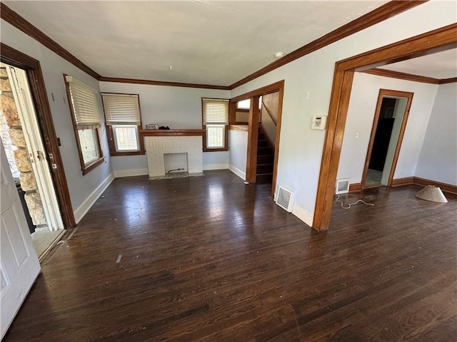 5647 Wayne Ave, Kansas City, MO 64110 - unfurnished living room with a brick fireplace, stairway, dark wood-style floors, and ornamental molding