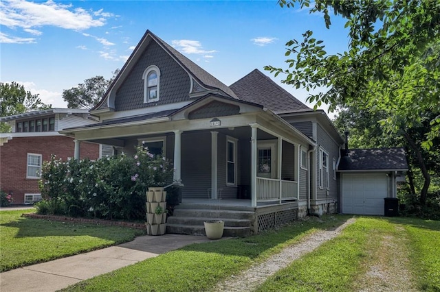 519 S Lincoln Ave, Chanute, KS 66720 - victorian-style house with a porch, a front yard, a garage, driveway, and a shingled roof