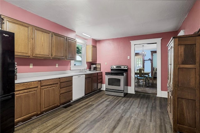 519 S Lincoln Ave, Chanute, KS 66720 - kitchen with white dishwasher, stainless steel electric range, freestanding refrigerator, dark wood-type flooring, and light countertops