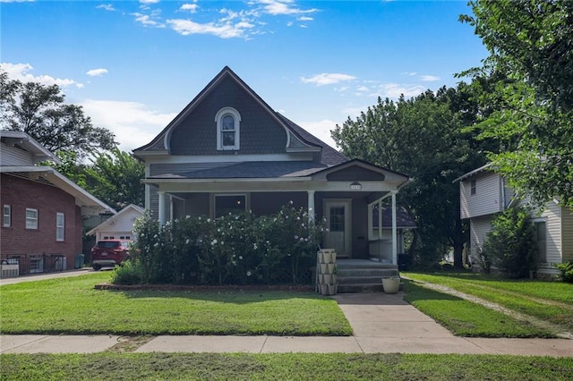 519 S Lincoln Ave, Chanute, KS 66720 - view of front of home with a porch, a front yard, and a shingled roof