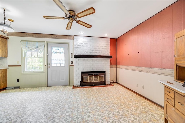 561 SW County Road O, Holden, MO 64040 - unfurnished living room featuring a ceiling fan, a brick fireplace, and wooden walls