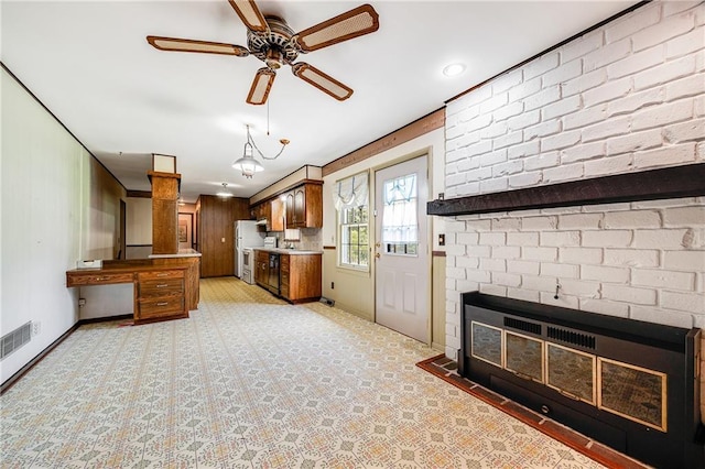 561 SW County Road O, Holden, MO 64040 - kitchen with a ceiling fan, a fireplace, light carpet, light countertops, and brown cabinetry