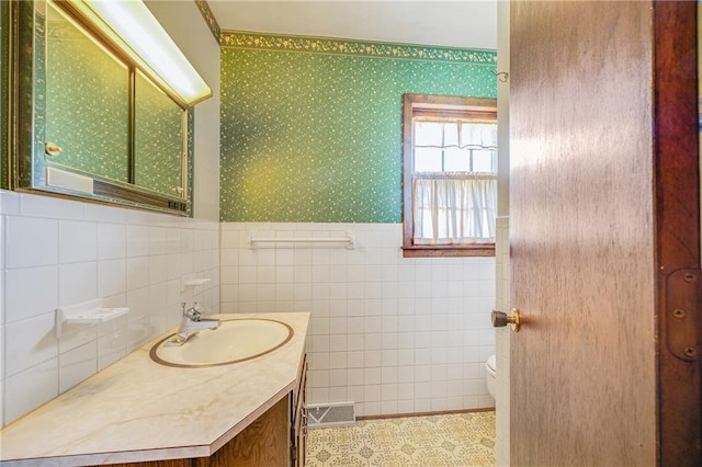 561 SW County Road O, Holden, MO 64040 - bathroom featuring vanity, tile walls, wainscoting, wallpapered walls, and tile patterned flooring