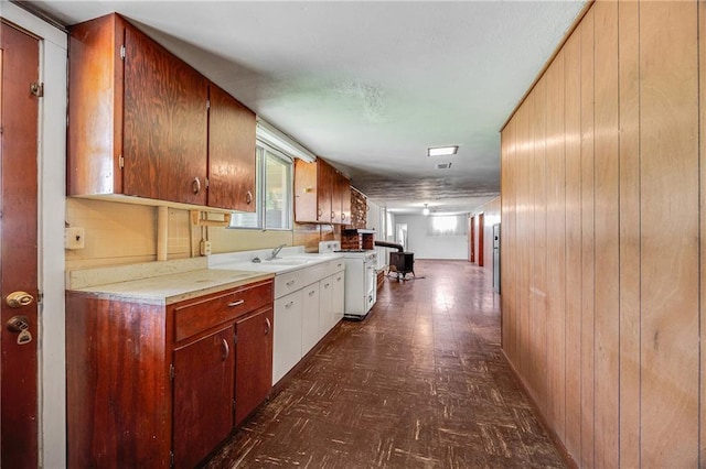 561 SW County Road O, Holden, MO 64040 - kitchen featuring wood walls, dark floors, light countertops, and stove
