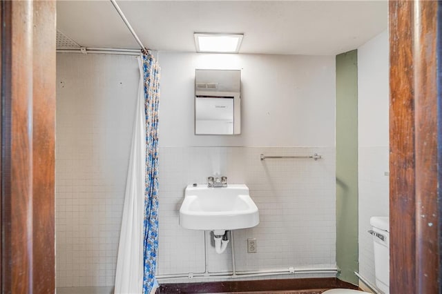 561 SW County Road O, Holden, MO 64040 - bathroom with tile walls, a shower with curtain, and wainscoting