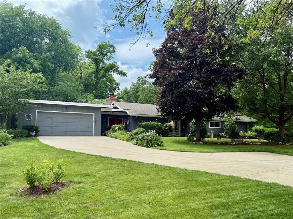 9820 State Line Rd, Leawood, KS 66206 - view of front facade featuring an attached garage, concrete driveway, a front yard, and a chimney