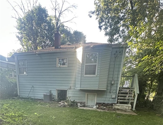 2209 E 72nd St, Kansas City, MO 64132 - back of property featuring a lawn, a chimney, and stairway