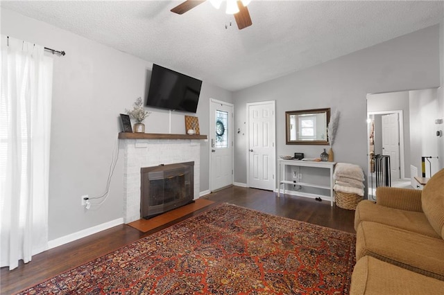 1101 Anderson St, Warrensburg, MO 64093 - living area featuring a ceiling fan, wood finished floors, a brick fireplace, a textured ceiling, and vaulted ceiling