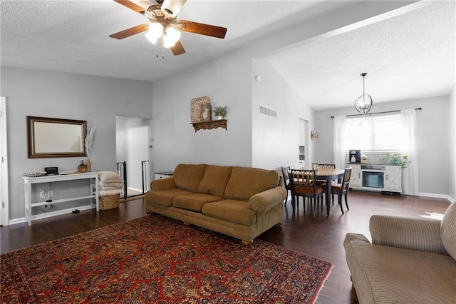 1101 Anderson St, Warrensburg, MO 64093 - living area with wood finished floors, lofted ceiling, a ceiling fan, a textured ceiling, and a chandelier