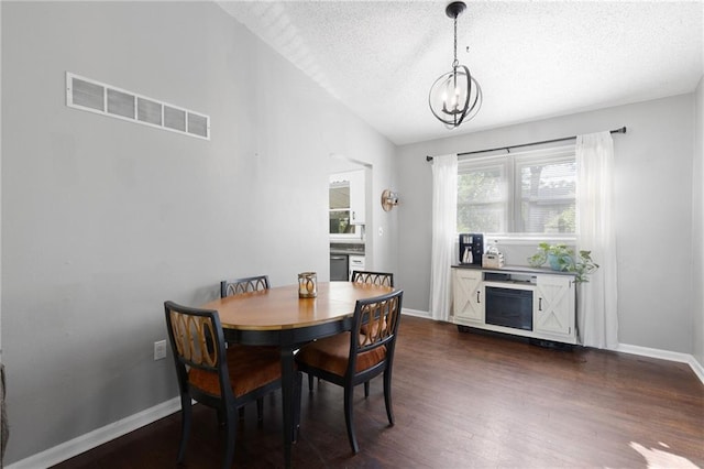 1101 Anderson St, Warrensburg, MO 64093 - dining space with a textured ceiling, a chandelier, and dark wood-type flooring