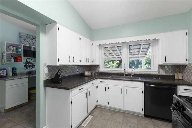 1101 Anderson St, Warrensburg, MO 64093 - kitchen with dishwasher, vaulted ceiling, stove, white cabinetry, and decorative backsplash