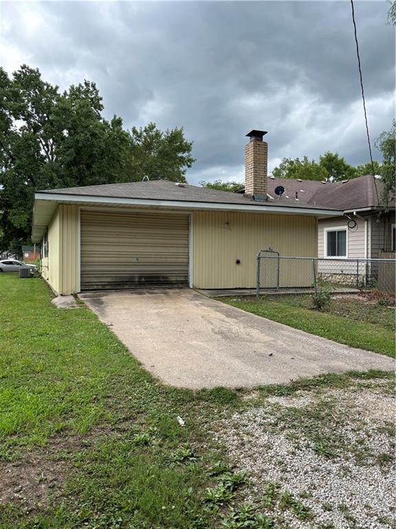 420 S Walnut St, Iola, KS 66749 - back of property with a chimney and concrete driveway