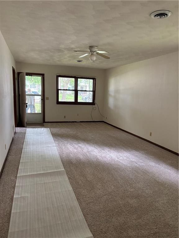 420 S Walnut St, Iola, KS 66749 - empty room with light colored carpet, a ceiling fan, and healthy amount of natural light