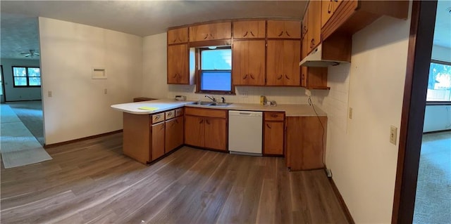 420 S Walnut St, Iola, KS 66749 - kitchen featuring dishwasher, dark wood-style floors, light countertops, brown cabinetry, and a peninsula