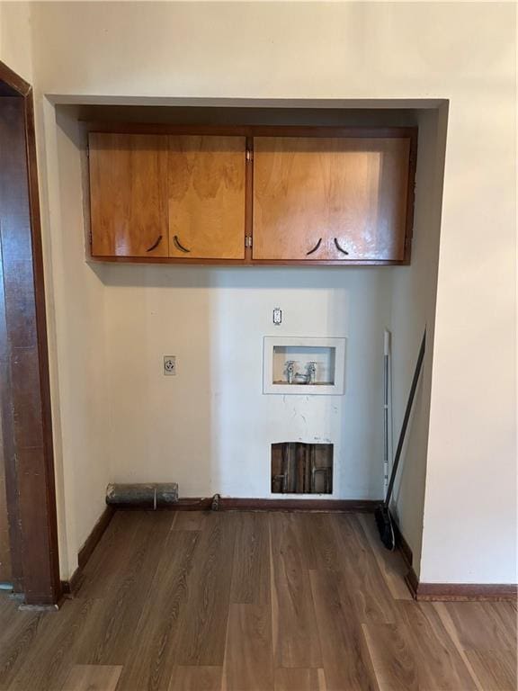 420 S Walnut St, Iola, KS 66749 - laundry area featuring cabinet space, hookup for a washing machine, electric dryer hookup, dark wood finished floors, and a fireplace