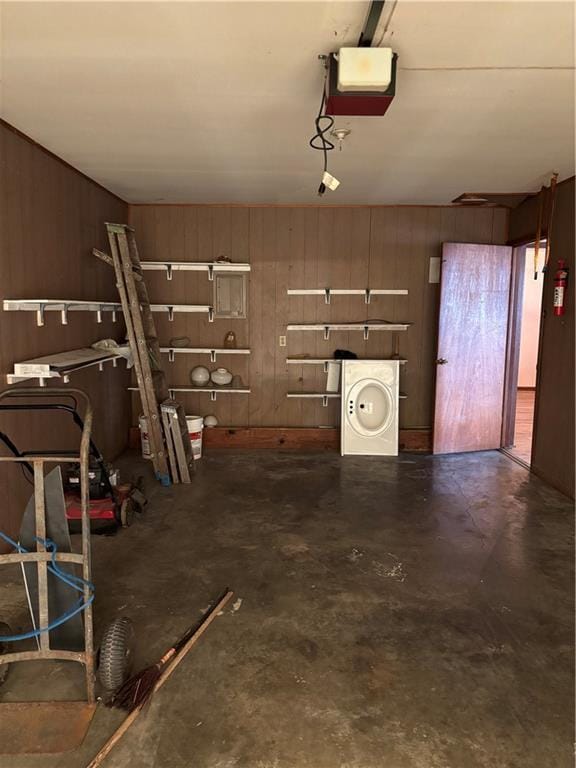420 S Walnut St, Iola, KS 66749 - garage with washer / clothes dryer, wooden walls, and a garage door opener