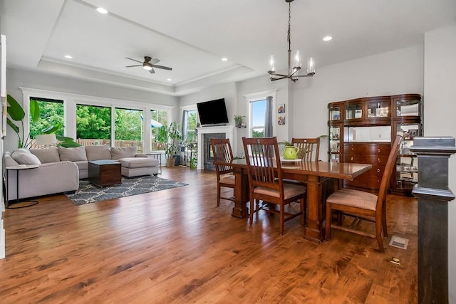 1034 SW Cheshire Dr, Lees Summit, MO 64083 - dining area featuring wood finished floors, a ceiling fan, a tray ceiling, a fireplace, and recessed lighting