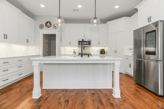 1034 SW Cheshire Dr, Lees Summit, MO 64083 - kitchen featuring appliances with stainless steel finishes, light countertops, decorative backsplash, a breakfast bar area, and recessed lighting