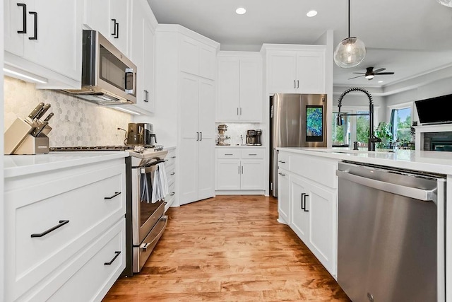 1034 SW Cheshire Dr, Lees Summit, MO 64083 - kitchen featuring appliances with stainless steel finishes, recessed lighting, tasteful backsplash, white cabinets, and light countertops