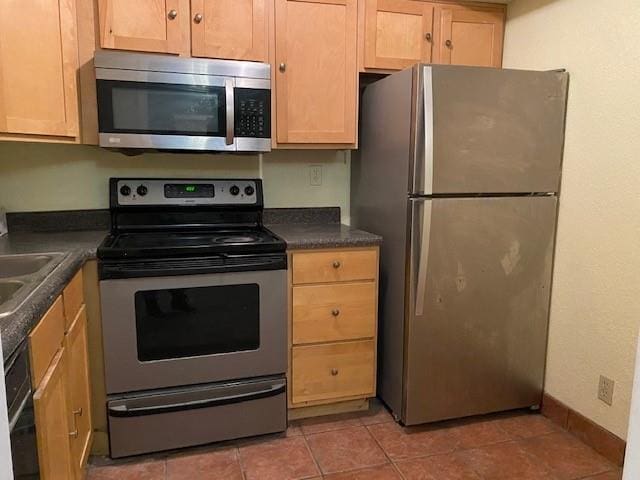 1848 E 97th St Unit C & D, Kansas City, MO 64131 - kitchen featuring appliances with stainless steel finishes, dark countertops, and light tile patterned flooring