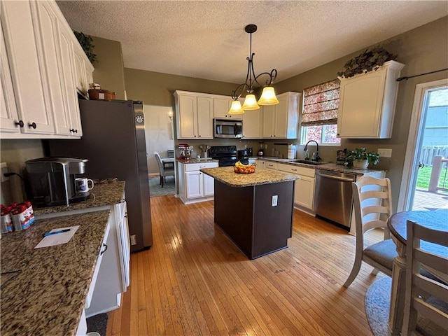 1840 W Fredrickson Cir, Olathe, KS 66061 - kitchen with appliances with stainless steel finishes, a center island, white cabinets, light stone countertops, and a textured ceiling